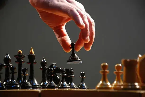 Mano moviendo una pieza de ajedrez sobre el tablero